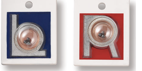 Two X-ray laterality markers, one blue reading "L" and one red reading "R," each with a small metal bead visible through a window near the bottom of the frame.